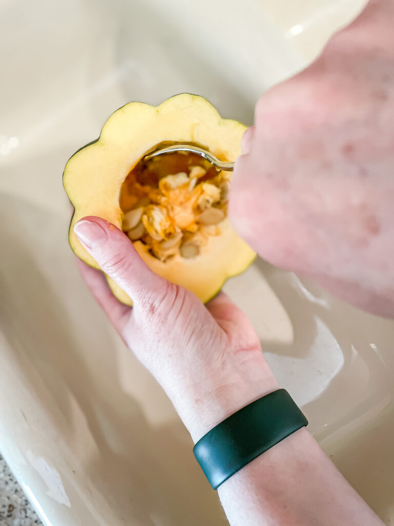 scooping out acorn squash